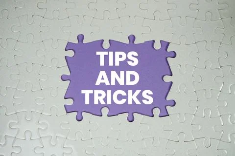 Jigsaw puzzle with a missing piece with "Tips and Tricks" on purple backgroun Stock Photos