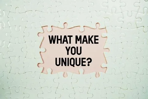 Jigsaw puzzle with a missing piece with "What Make You Unique?" on pink bac.. Stock Photos