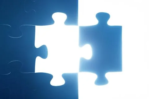 Jigsaw puzzle piece missing. Light glow from empty space. Search for the solu Stock-Fotos