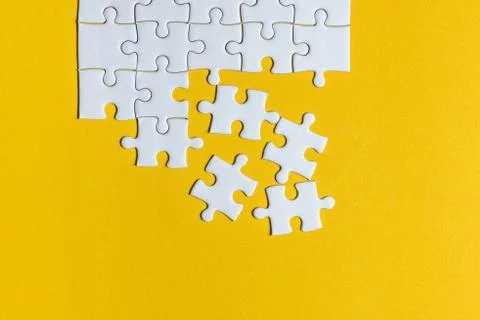 Jigsaw puzzles placed on a yellow background Creative concept with copy space Foto stock