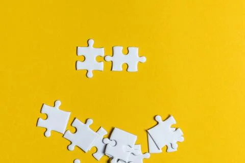 Jigsaw puzzles placed on a yellow background Creative concept with copy space Foto stock