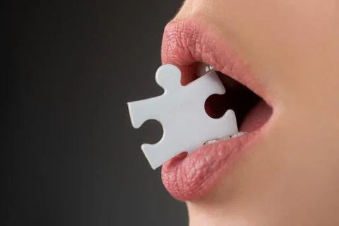Jigsaw solution. Life problems. Female mouth with puzzle piece. Stockfoto's