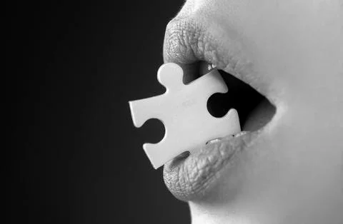 Jigsaw solution. Life problems. Female mouth with puzzle piece. Stockfoto's