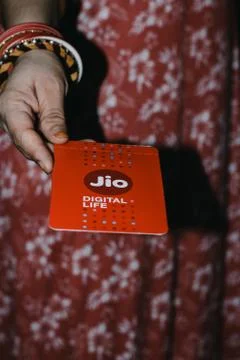 Jio SIM cards in hand with every JioFi or 4G smartphone Foto stock