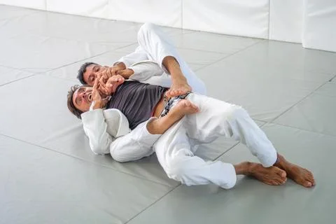 Jiu jitsu partners practicing choke defense from back control Stock-Fotos