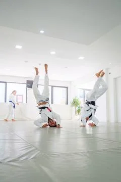 Jiu jitsu students balancing in headstands during warm up Stock-Fotos