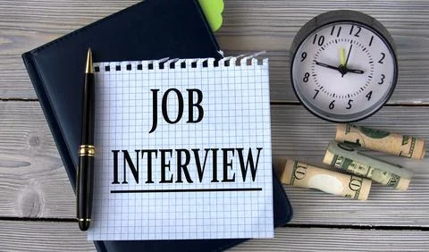 JOB INTERVIEW - words in a white notebook on the background of an alarm clock Stock Photos