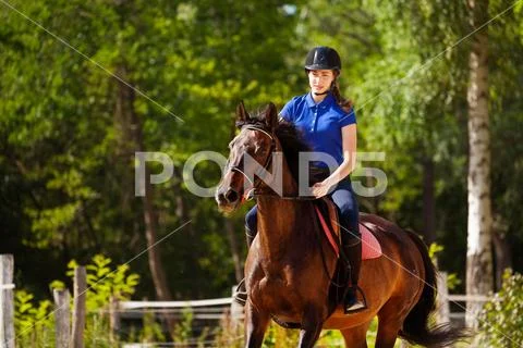 Jockey girl training horse at racetrack in summer Stock Photos