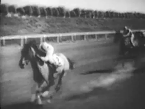 Jockey looking back at his competitors during horse race, 1940s Video stock 64820372