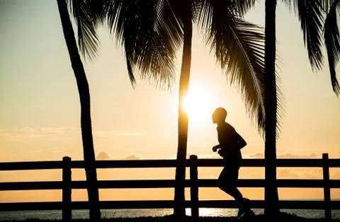 Jogger at the beach for sunset Stock Photos