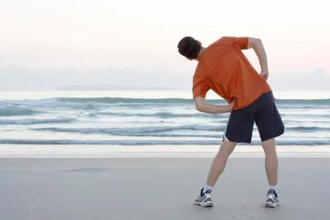 Jogger doing stretching on a beach 写真素材