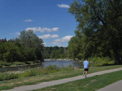 Jogger on path beside a river Stock Photos