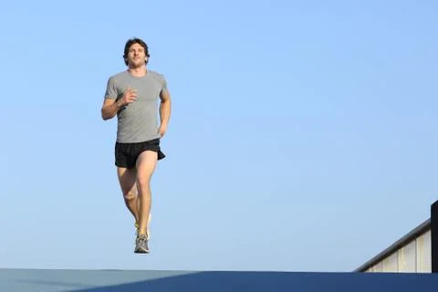 Jogger running towards camera on blue Stock Photos
