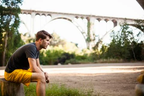 Jogger taking break, arch bridge in background, Arroyo Seco Park, Pasadena, Fotos Stock