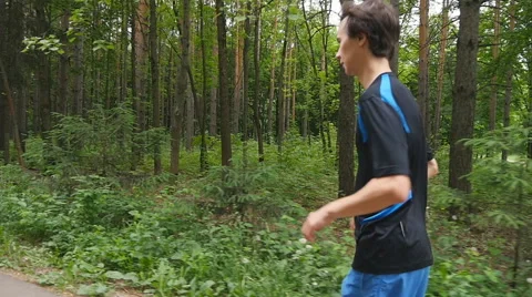 Jogger on a trail in the forest in slow motion Stock Footage 63971349