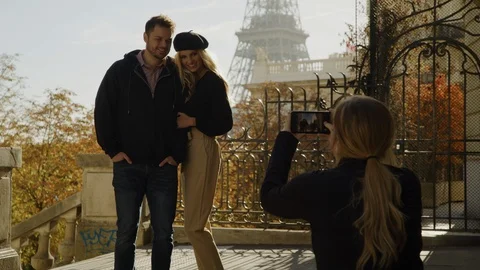 Jogger using cell phone to photograph couple near Eiffel Tower / Paris, Ile de Stock Footage 100787792
