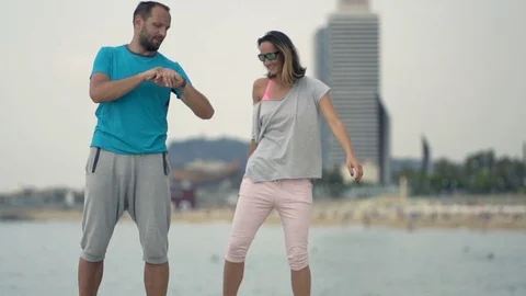 Joggers checking time on smartwatch on beach in city, super slow motion 240fps Stock Footage 79209951