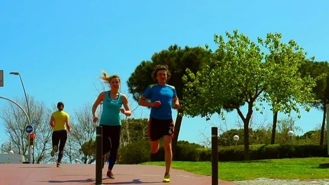 Joggers passing each other while running, steadycam shot, slow motion shot  Stock Footage 72203216