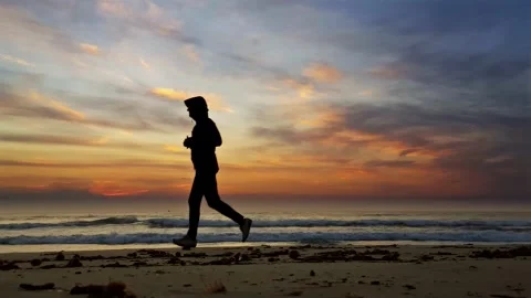 Jogging on Beautiful Beach by Dramatic  Sunrise - loop able slow motion 動画素材 297266639