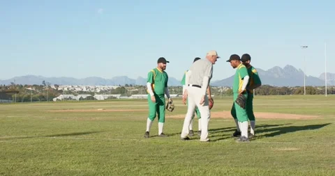 Jogging in post inning coach joins diverse baseball team celebrating on mound Stock Footage 337704500