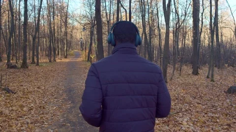 Jogging to rhythmic music among the trees in the autumn grove. The trail is Stock Footage 164233412
