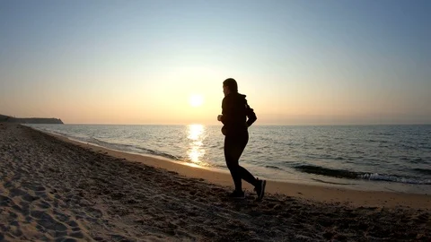 Jogging on the sandy beach at sunset Stock Footage 108070773