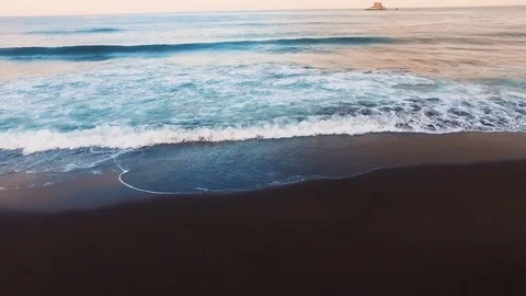 Jogging with the stabilizer of a camera on the beach. Waves are hitting right in Stock Footage 73061429