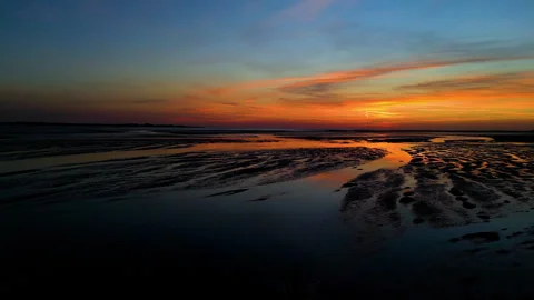 Jogging through water on the beach at dusk in slow motion drone shot Stock Footage 286066132