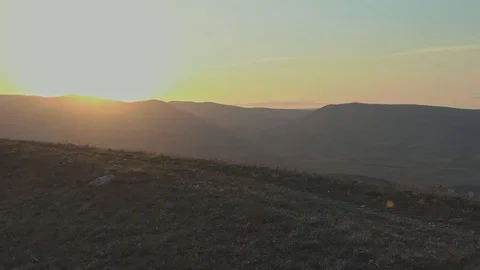 Jogging on top of a hill against the backdrop of a mountain panorama in the Stock Footage 129608145
