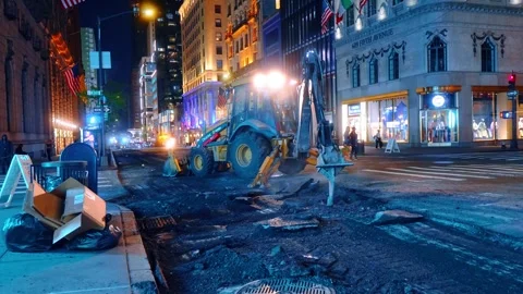John Deere backhoe loader excavating street surface at night Stock Footage 333213922