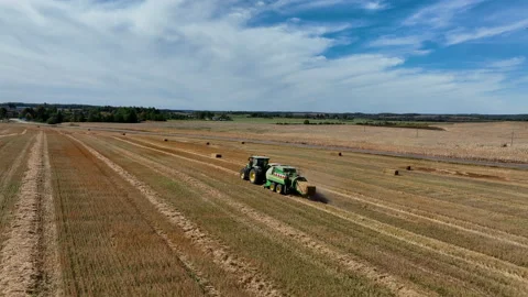 John Deere L1534 Square Baler making Hay Bales in an agricultural field. Video stock 211477897