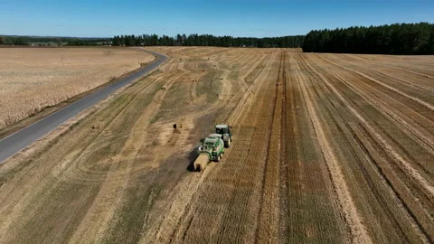 John Deere L1534 Square Baler making Hay Bales in an agricultural field. 動画素材 212026742