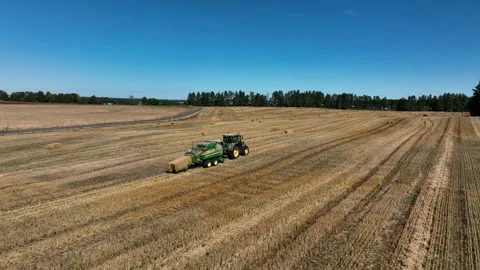 John Deere L1534 Square Baler making Hay Bales in an agricultural field. Stock Footage 212087129