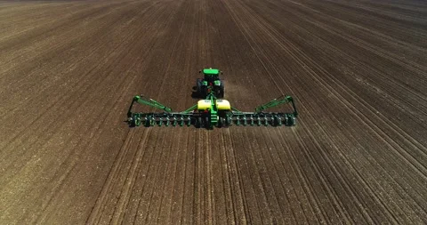 John Deere tractor and planter going across a freshly tilled field with Stock Footage 142571197