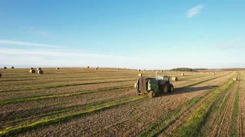 John Deere Tractor with round baler making Hay Bales Stock Footage 206407669