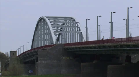 John Frost Bridge - low angle, cyclists + traffic + zoom out river foreland Stock Footage 22982972