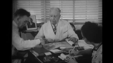 John W Houserman looking at map and discussing with other officer Stock Footage