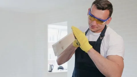 Joiner check the smoothness of plank in his hands. Carpenter and wooden board Stock Footage 130452543
