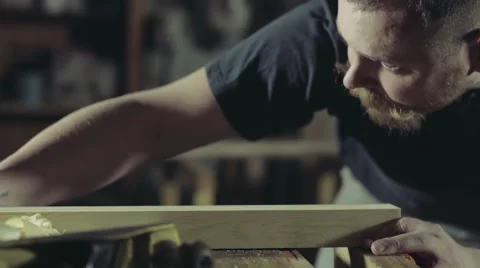 Joiner checks his work looks at the plane of the workpiece Stock Footage 47972048