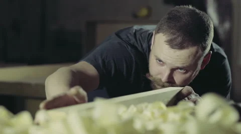 Joiner checks his work looks at the plane of the workpiece Stock Footage 47973514