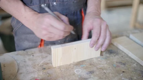 Joiner making marks with pencil and screwdriver on piece of wood Stock Footage 104626212