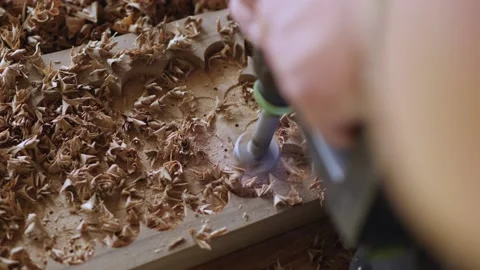 A joiner processes a walnut board with a wood cutter. the art of woodworking  Stock Footage 144243872