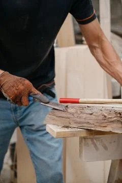 A joiner processes a workpiece with a chisel. Foto stock
