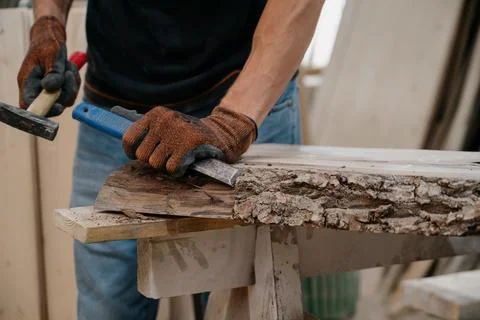 A joiner processes a workpiece with a chisel. Stock Photos