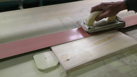 A joiner using a belt sander grinds the product. Stock Footage 116379220