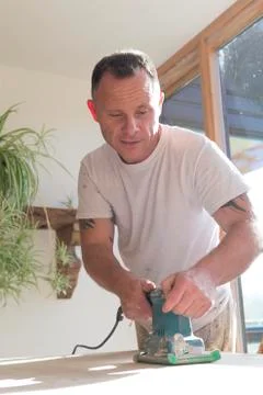 Joiner using a sander on a table surface Fotos Stock
