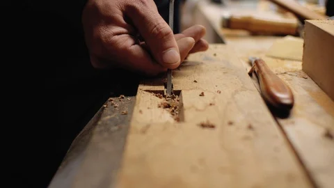 Joiner working narrow chisel on wooden board close up.4k Stock Footage 105637865