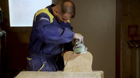 The joiner works with an electric sander in the workshop. Stock Footage 100877909