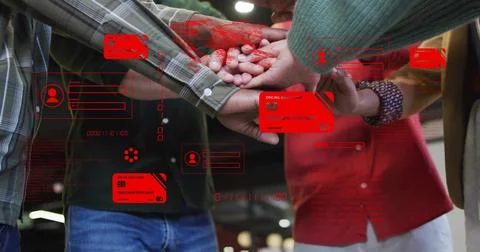 Joining colleagues placing hands in open-plan office, with red credit-card ic Stock Photos
