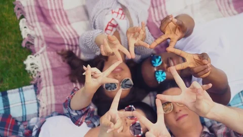 Joining hands students show a star lying on rugs on the grass Stock Footage 126282837